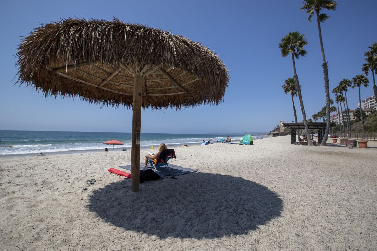 Beachgoers enjoy a warm, sunny day  near the San Clemente pier on Wednesday.