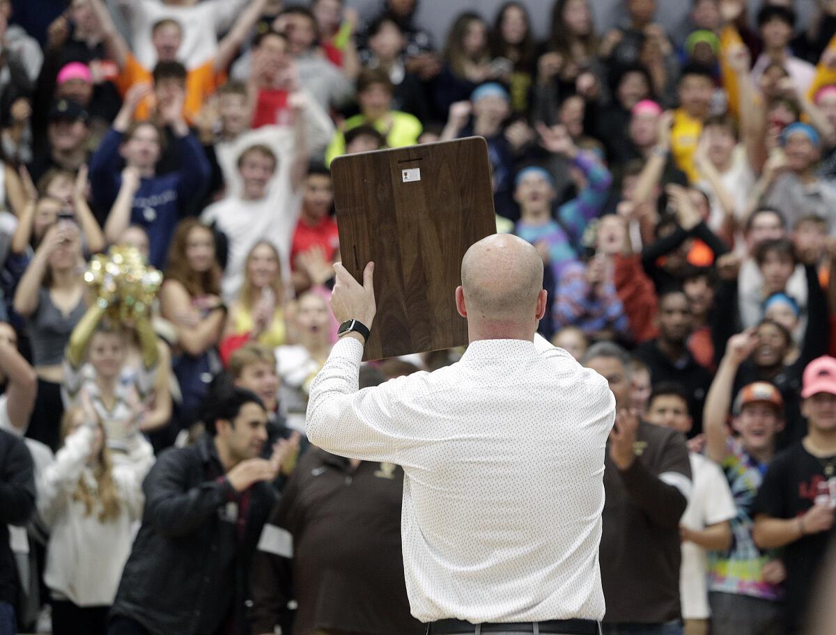 St. Francis' head coach Todd Wolfson holds up the championship trophy on display for the student section in the Southern California Regional title game of the Division II CIF State Championship at St. Francis High School on Tuesday, March 10, 2020. St. Francis lead for the entire game, defeating the Mustangs 53-44 in front of a more than standing room only crowd.