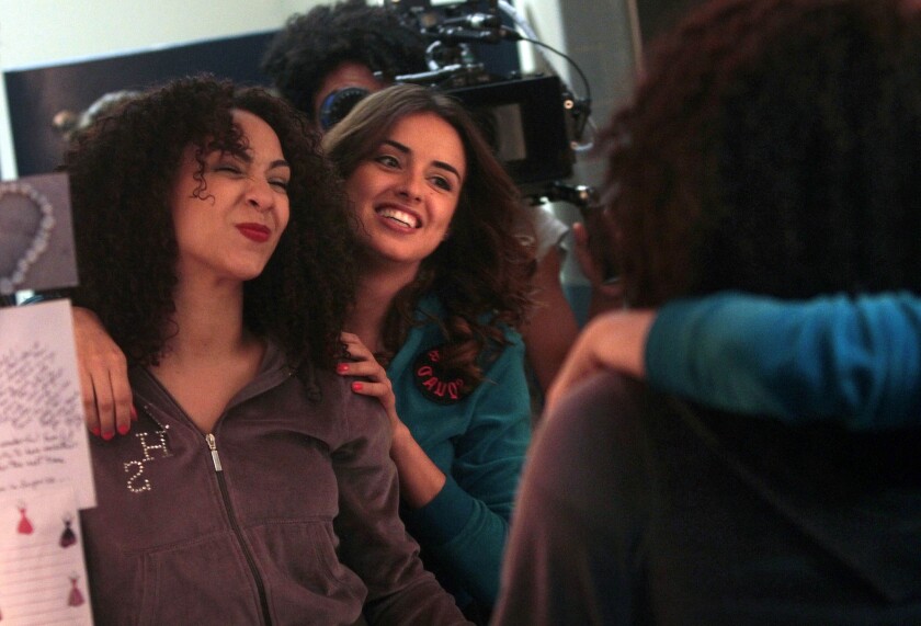 Monica Ramirez, "Yvonne," left, and Vannessa Vasquez, "Camilla," right, joke around looking into the mirror as they rehearse a fight scene during filming of "East Los High" at Plaza de la Raza for Hulu.