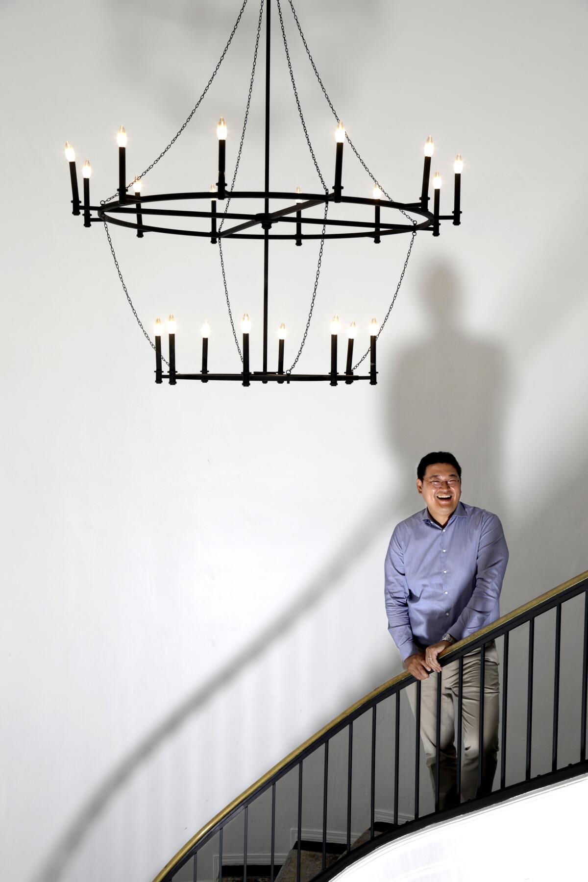 A man in a button-down shirt stands on a staircase at Wiip, a Hollywood production company.