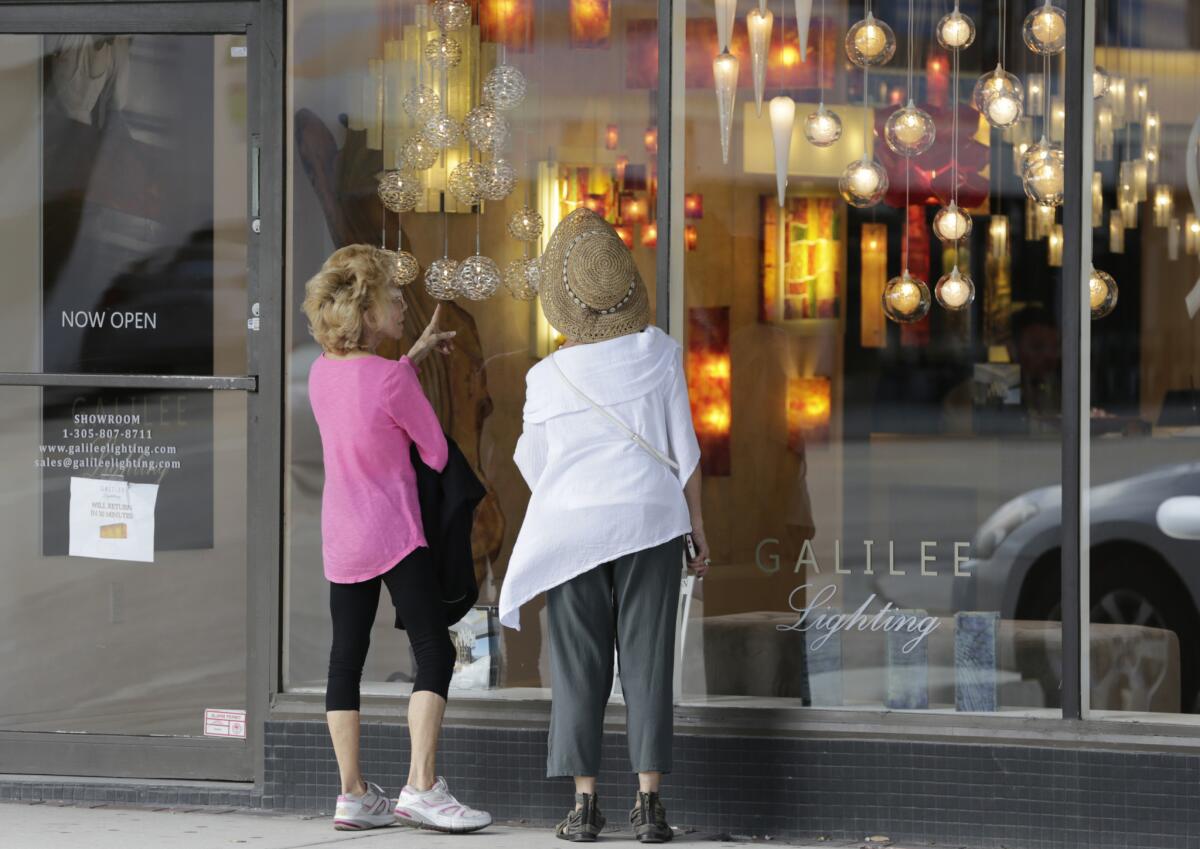 Shoppers stop to look in the window of a lighting store in the Design District of Miami Beach, Fla., on Feb. 3.
