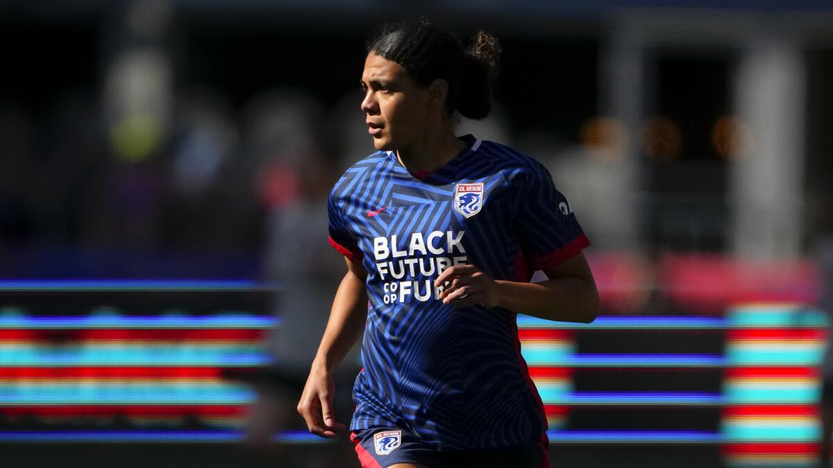 OL Reign defender Alana Cook jogs on the pitch against the Portland Thorns.