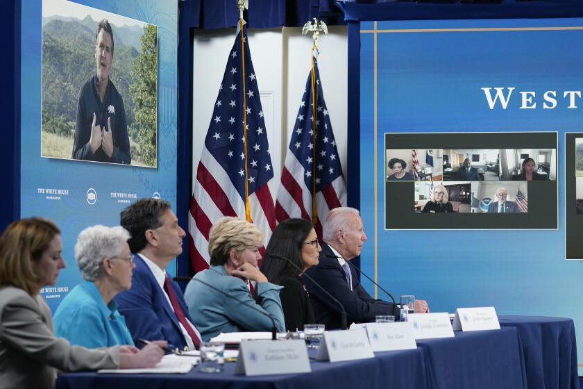 President Joe Biden, right, listens as California Gov. Gavin Newsom, on screen, speaks during an event in the South Court Auditorium on the White House complex in Washington, Wednesday, June 30, 2021, with cabinet officials and governors from Western states to discuss drought and wildfires. Others a the table are, from left, Deputy Secretary of Defense Kathleen Hicks, National Climate Adviser Gina McCarthy, White House chief of staff Ron Klain, Energy Secretary Jennifer Granholm and Interior Secretary Deb Haaland. (AP Photo/Susan Walsh)