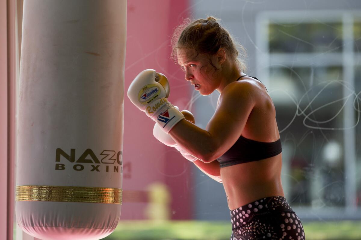 Mixed martial arts fighter Ronda Rousey works out on the heavy punching bag at Glendale Fighting Club in July.