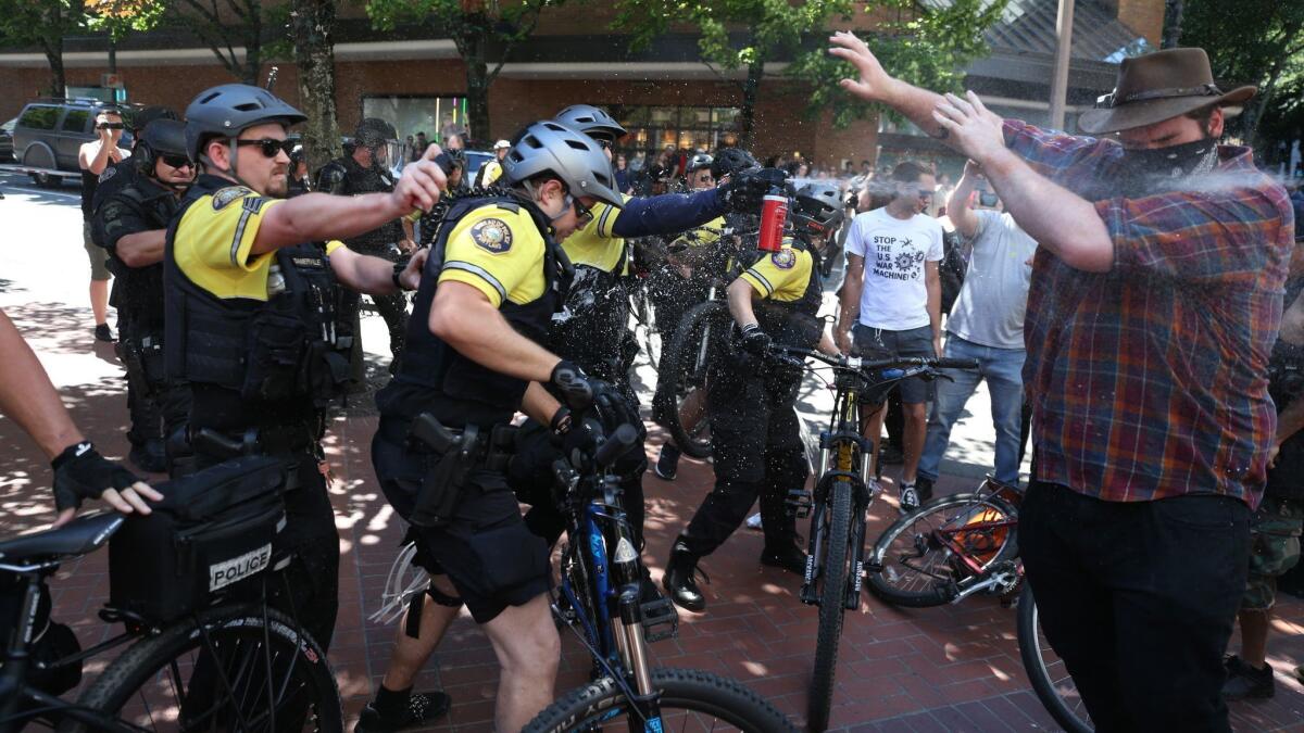 After a confrontation between authorities and protesters, police use pepper spray as multiple groups, including Rose City Antifa, the Proud Boys and others, protest in downtown Portland on Saturday.