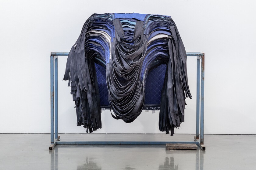 “Rack of Aprons” by Theaster Gates, 2019. Restitched moving mats, still rack, bronze, 52.5 inches by 54 inches by 60 inches.