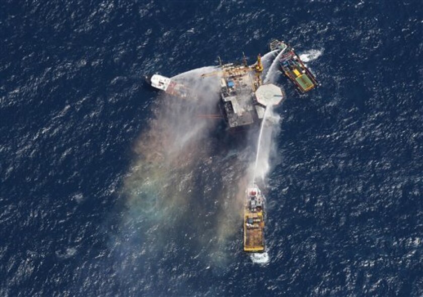 Boats are seen spraying water on an oil and gas platform that exploded in the Gulf of Mexico, off the coast of Louisiana., Thursday, Sept. 2, 2010. All 13 crew members were rescued. (AP Photo/Gerald Herbert)