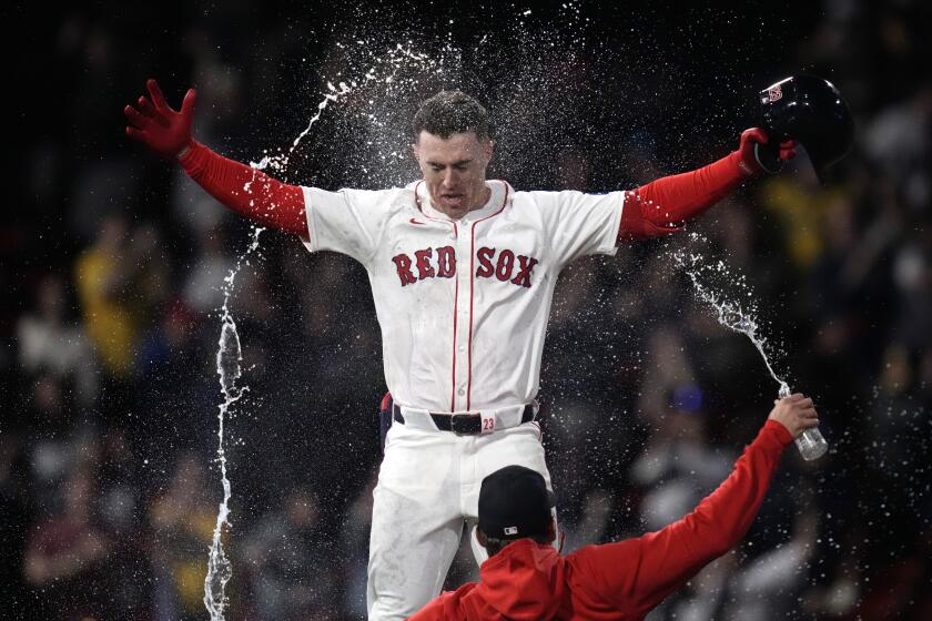 Romy Gonzalez de los Medias Rojas de Boston es bañado en agua luego de conectar el sencillo ganador en la 12ma entrada del juego de béisbol ante los Rays de Tampa Bay en el Fenway Park, el martes 14 de mayo de 2024, en Boston. (AP Foto/Charles Krupa)
