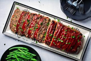 A tray of meatloaf with a side of steamed green beans.