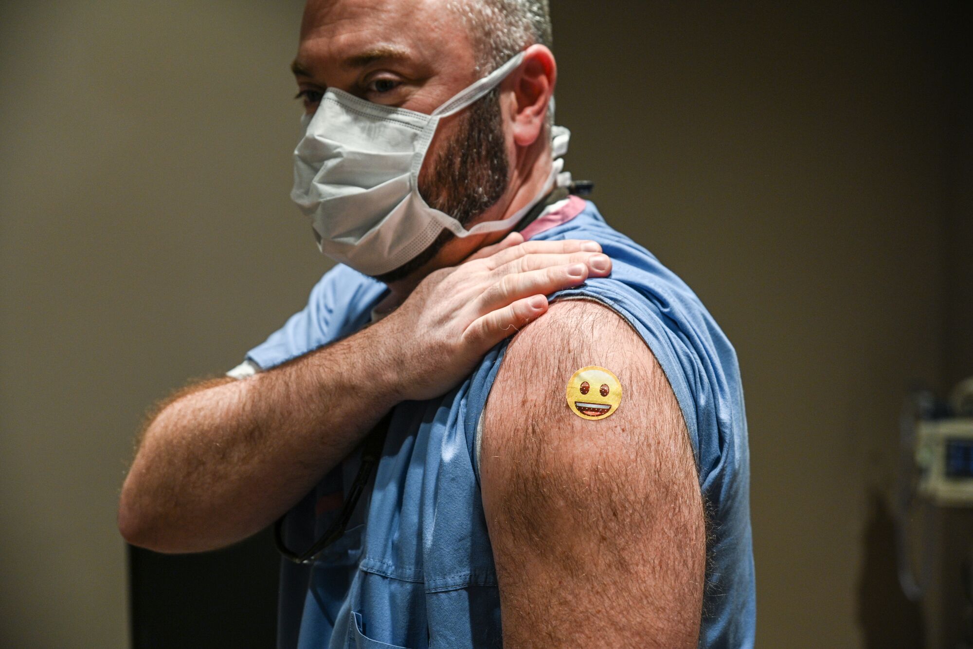 Dr. Jason Smith displays a smiley bandage on his shoulder
