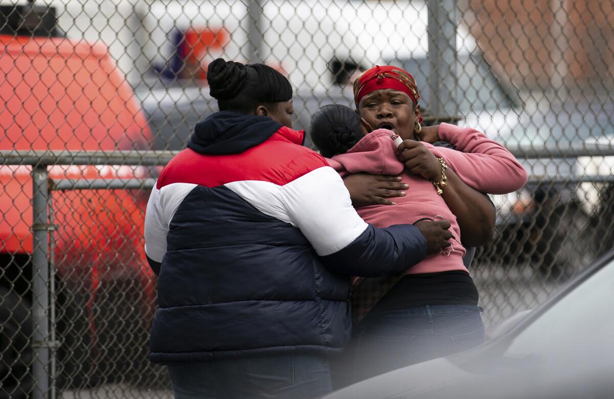 People embrace at the scene of a shooting in Brooklyn on Oct. 12