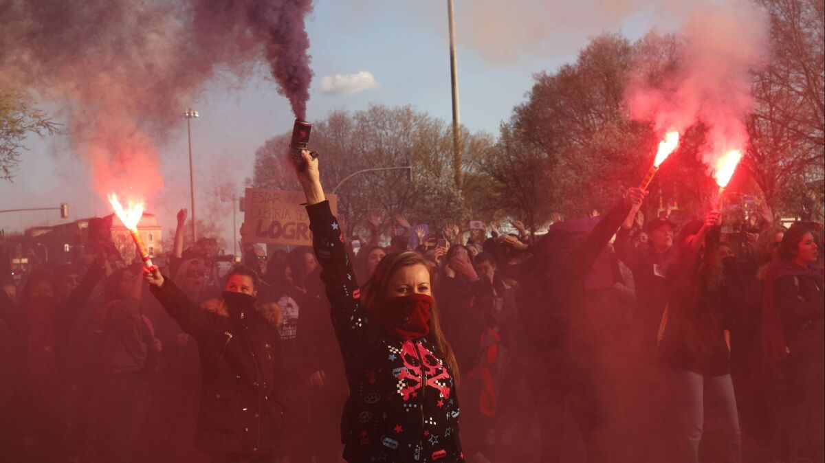 Women march holding flares in Madrid on March 8 for International Women's Day.