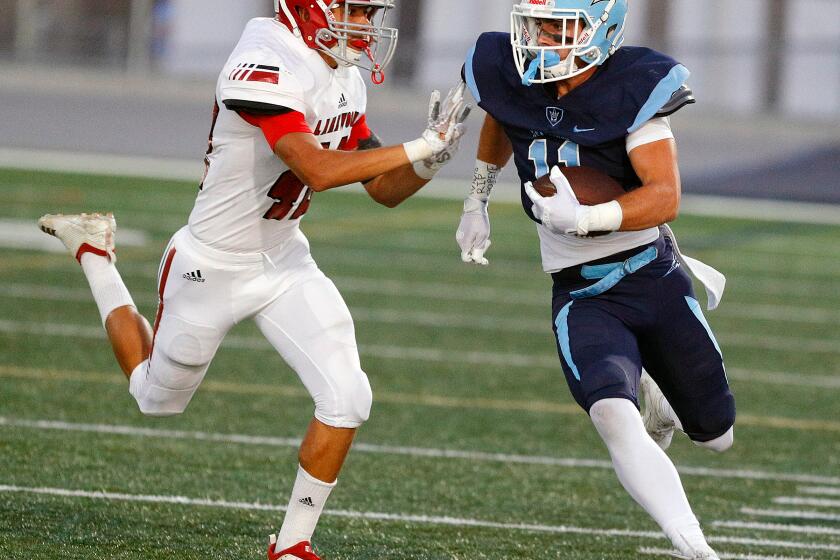 Corona del Mar's Bradley Schlom takes a reception and runs for a first down against Lakewood's Travis Perryman in a non-league football game at Newport Harbor High School on Friday, September 13, 2019.
