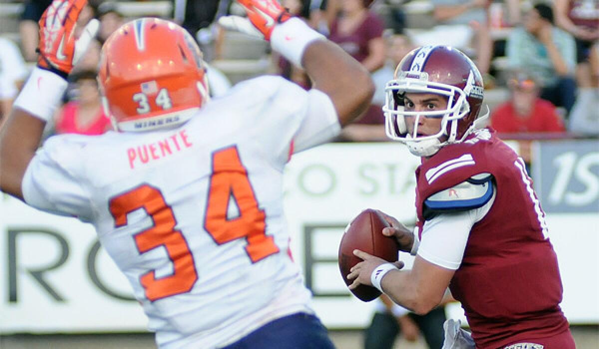 New Mexico State University quarterback Andrew McDonald, right, looks to make a pass over UTEP defender Anthony Puente on Sept. 14.