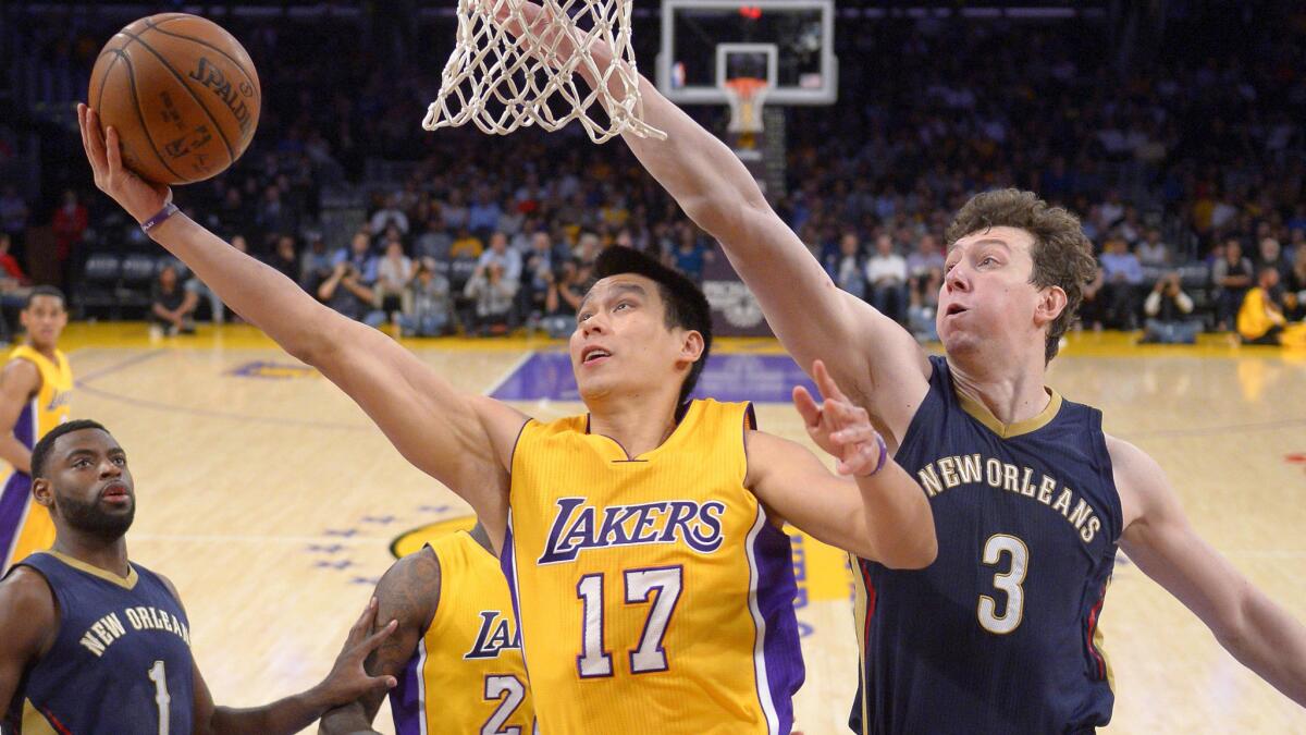 Lakers guard Jeremy Lin, left, puts up a shot in front of New Orleans Pelicans center Omer Asik during the Lakers' 113-92 loss at Staples Center on April 1.
