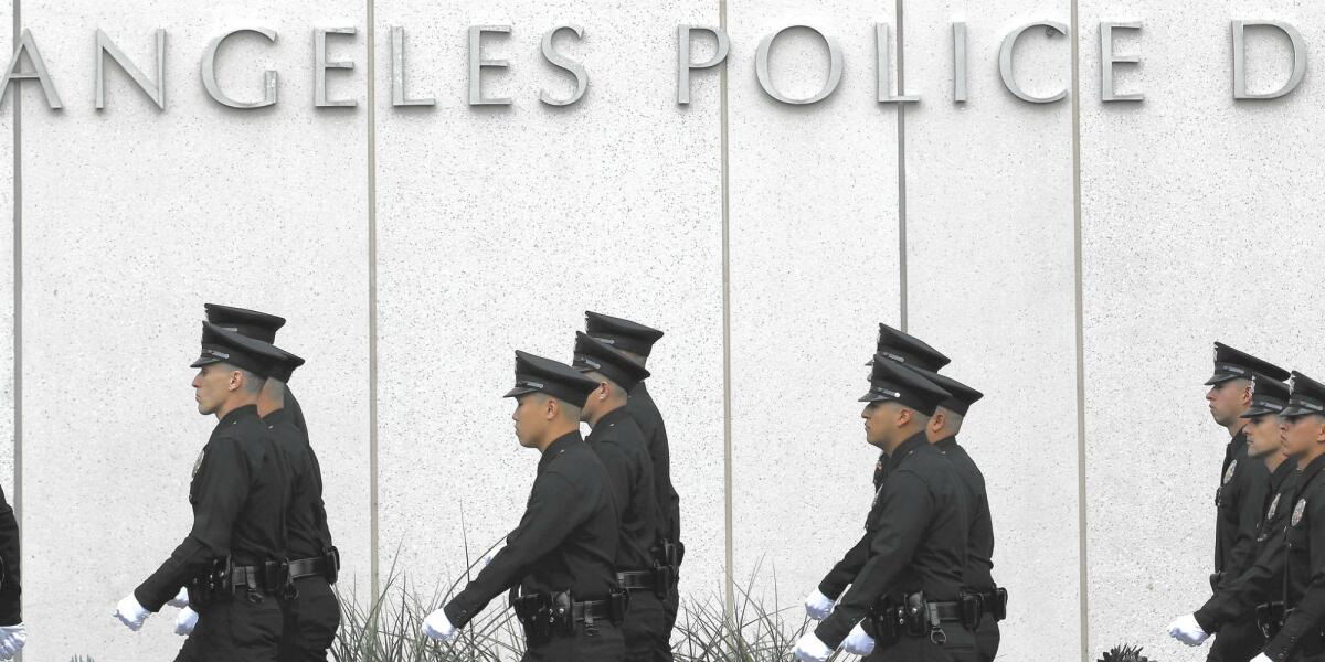 Los Angeles police officers walk past the department's headquarters.