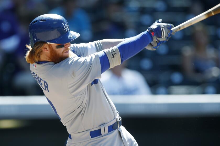 Dodgers third baseman Justin Turner hits a single off Colorado Rockies reliever John Axford during a game June 2.