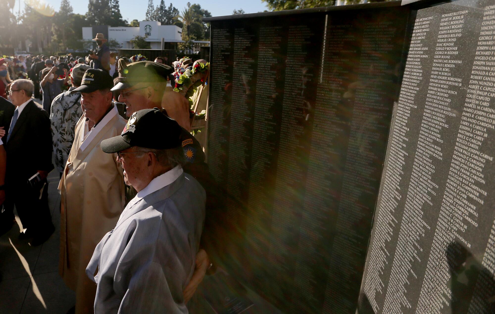 Veterans pose for pictures at the Korean War memorial at Hillcrest Park in Fullerton