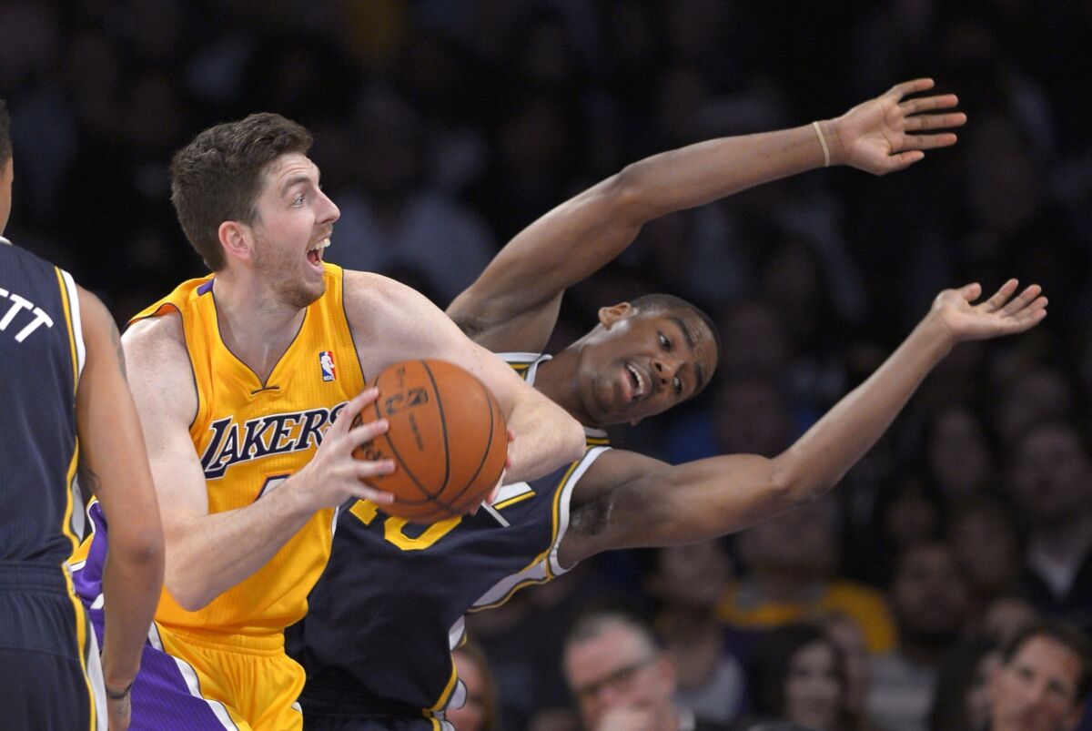 Lakers forward Ryan Kelly tries to get past Jazz guard Alec Burks on a driver to the basket in the first half.
