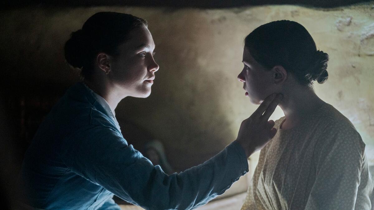 A woman strokes a young girl's face in "The Wonder," a movie set in 19th-century Ireland.