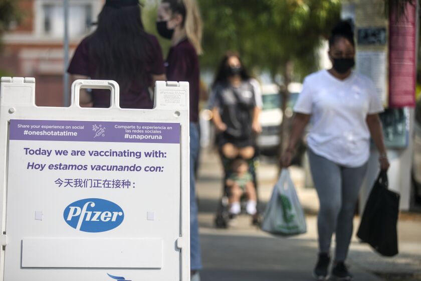 LOS ANGELES, CA - AUGUST 17, 2021- Staff members from AltaMed Health Services, left, wait for patients at a COVID-19 vaccine event hosted by councilman Curren Price on Tuesday, Aug. 17, 2021 in Los Angeles, CA. The first 200 people between the ages of 12 and 20 who got vaccinated at the event received a free pair of Beats by Dre headset. (Brian van der Brug / Los Angeles Times)