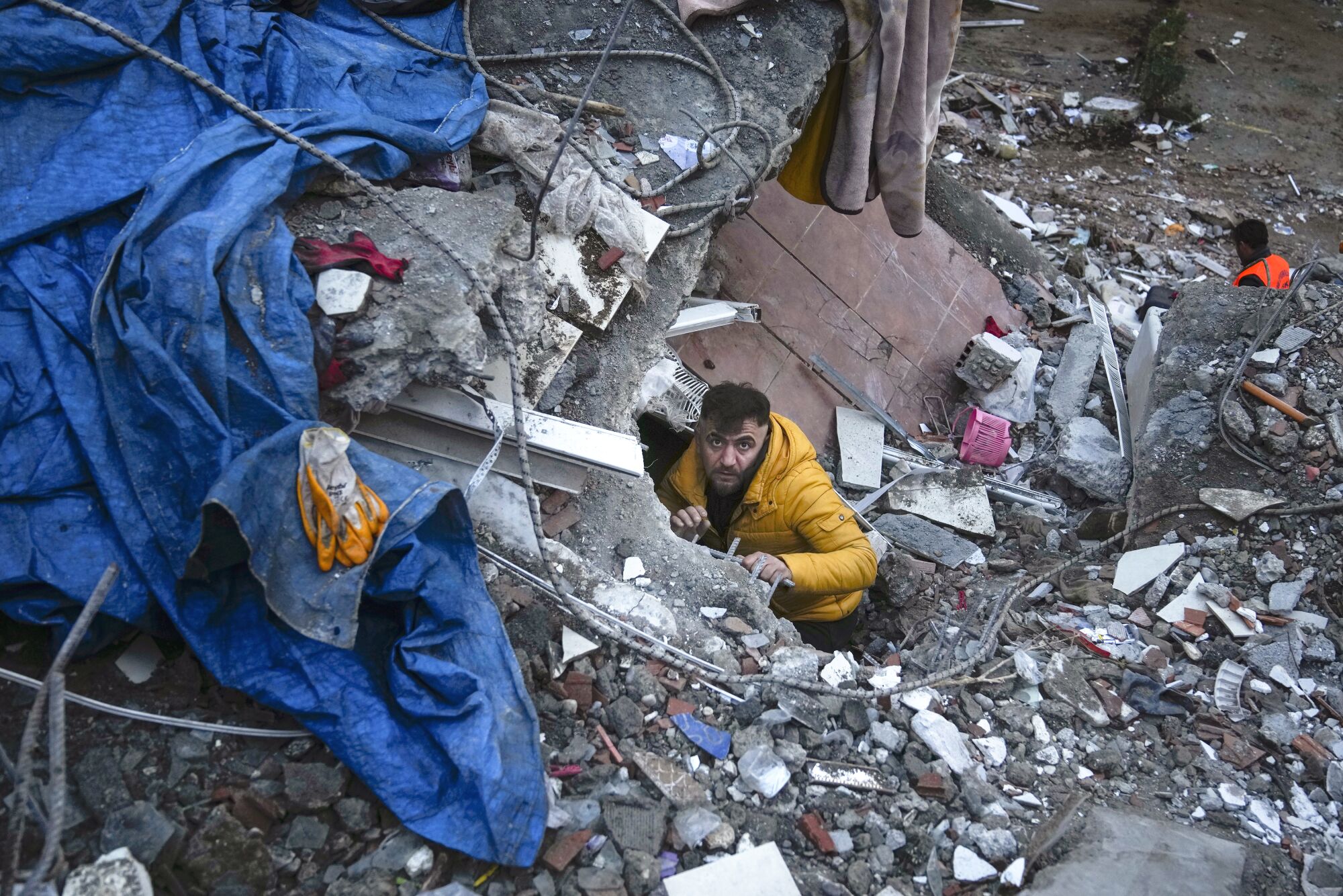 A man searches for people in a destroyed building Monday in Adana, Turkey.