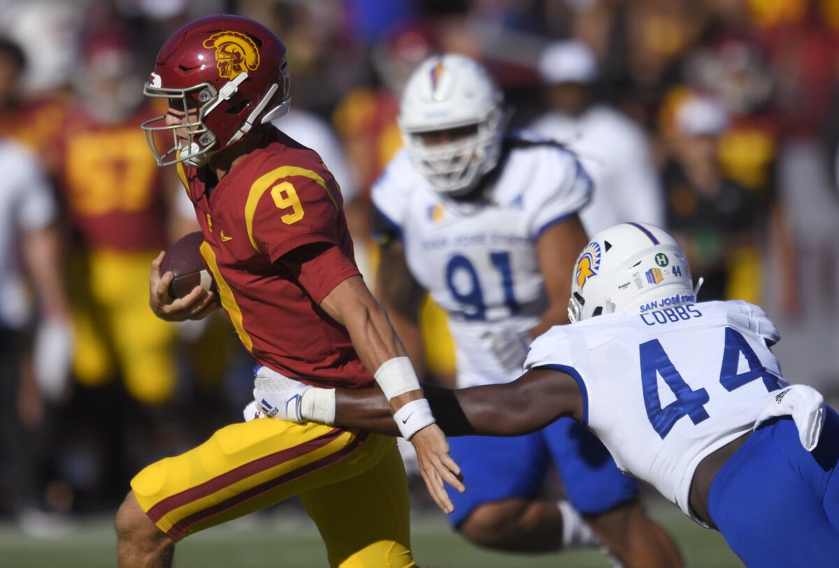 USC quarterback Kedon Slovis runs past San Jose State Spartans linebacker Jordan Cobbs.