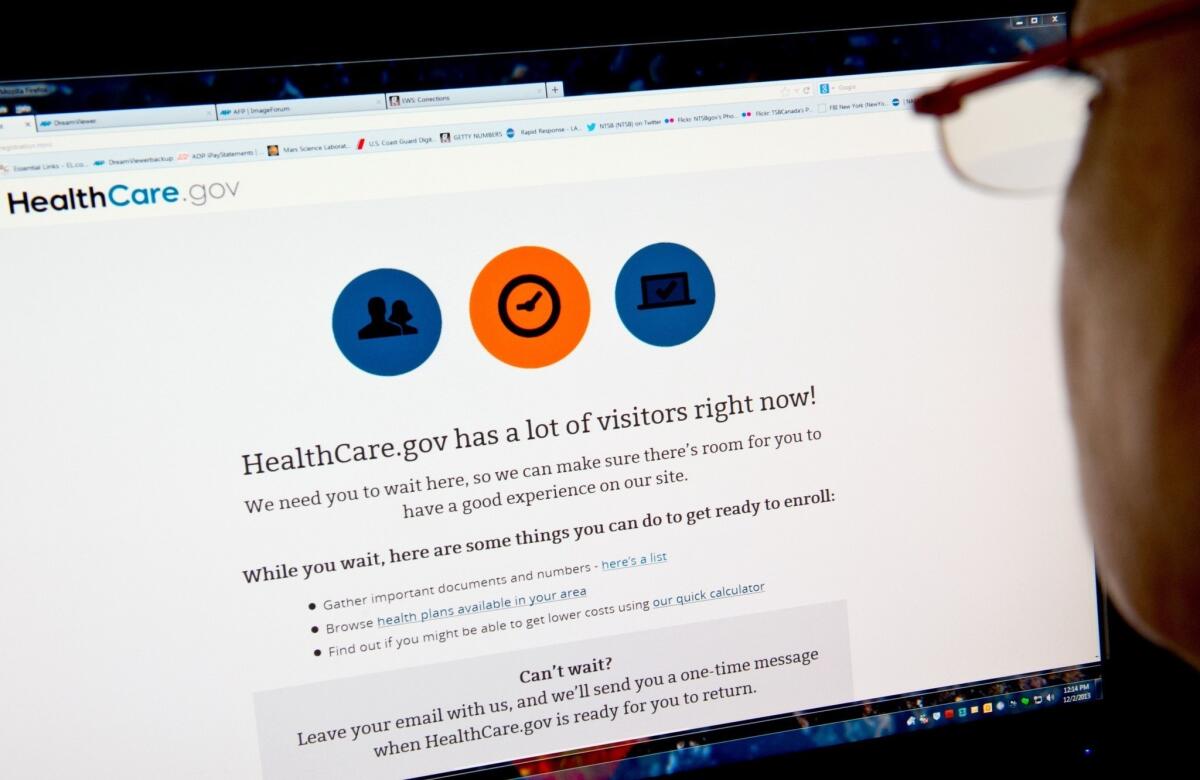 A woman reads a message indicating that the HealthCare.gov insurance marketplace website has too much traffic to continue enrollment.
