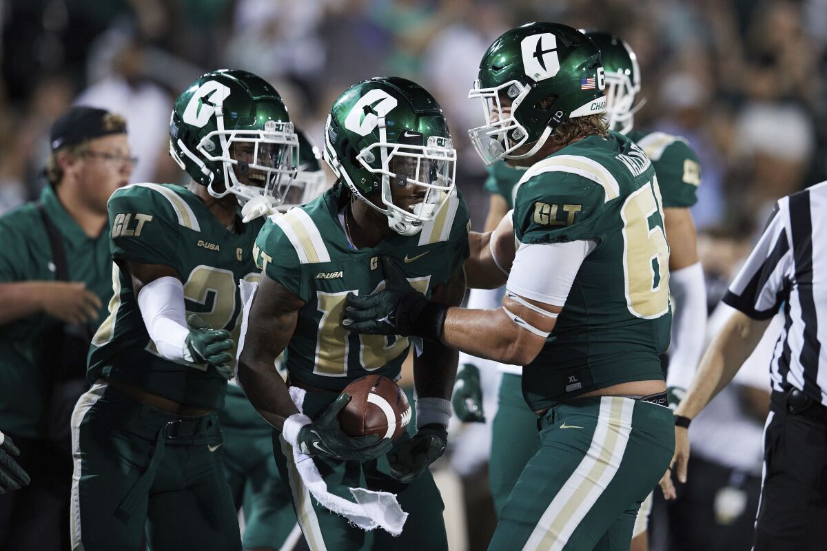 Charlotte defensive back Valerian Agbaw (16) is congratulated by teammates after recovering a fumble during the team's NCAA college football game against Duke on Friday, Sept. 3, 2021, in Charlotte, N.C. (AP Photo/Brian Westerholt)