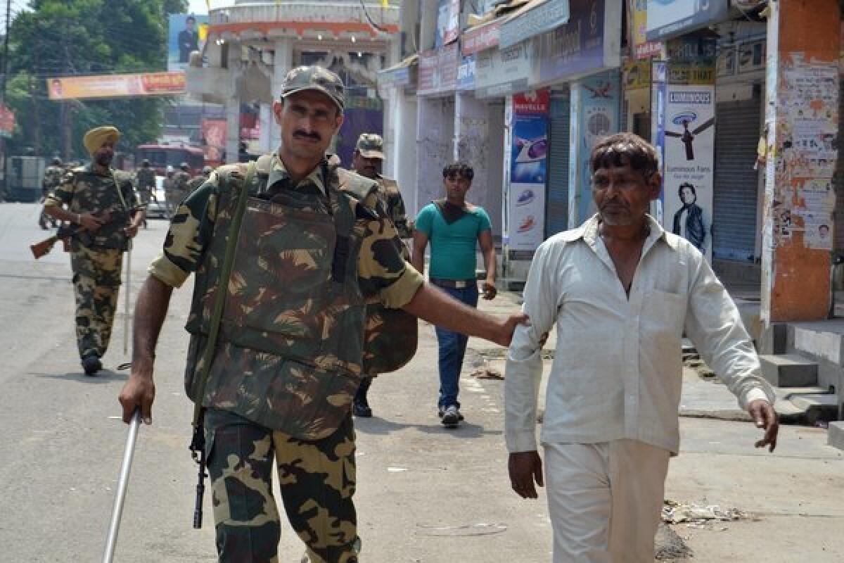 Indian soldiers detain two men following riots between Muslims and Hindus in Muzaffarnagar in Uttar Pradesh state.