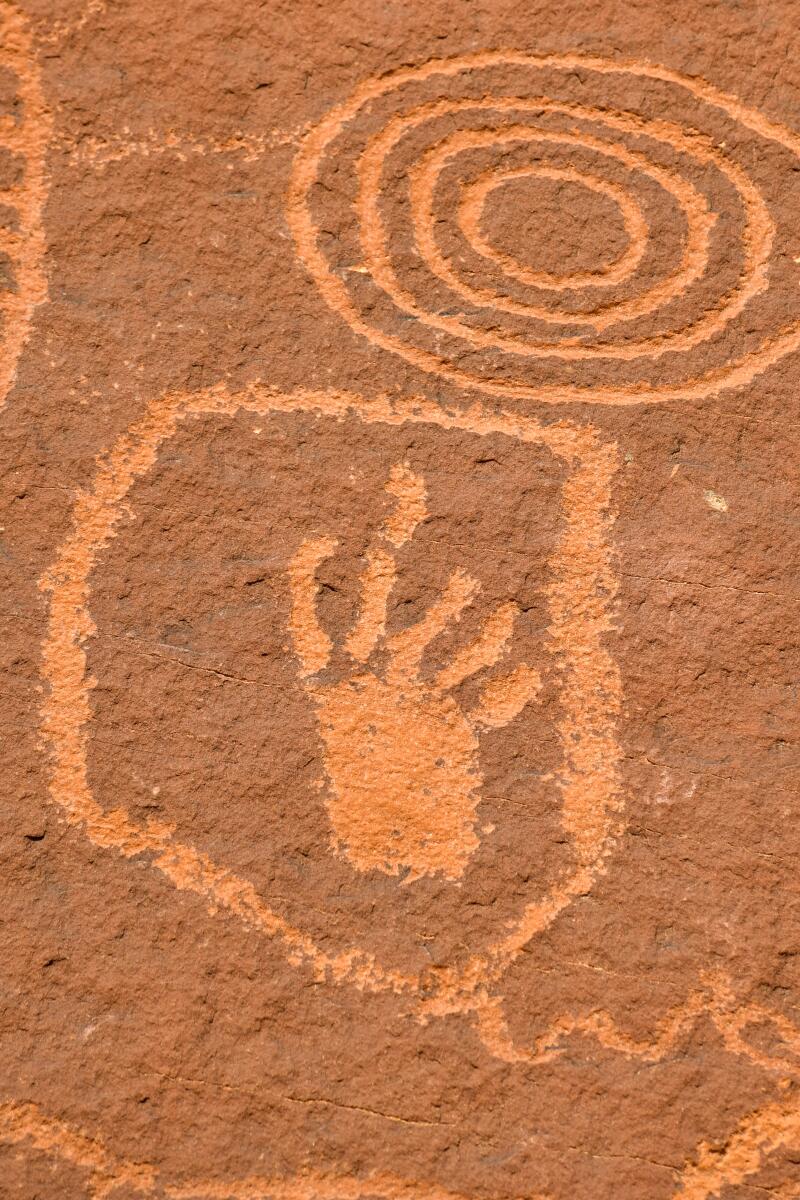 Petroglyphs of a hand within a kite shape next to a spiral at Valley of Fire State Park.