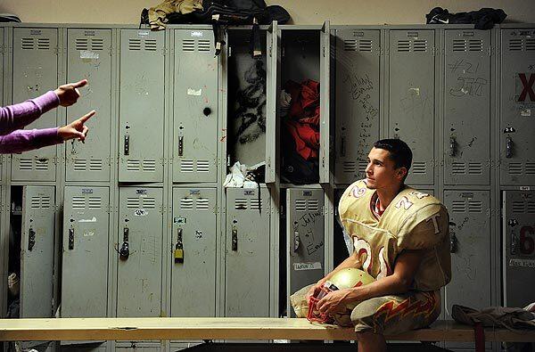Varsity football player Nick Conway watches sign language interpreter Gina Campbell in the locker room at Taft High School in Woodland Hills.
