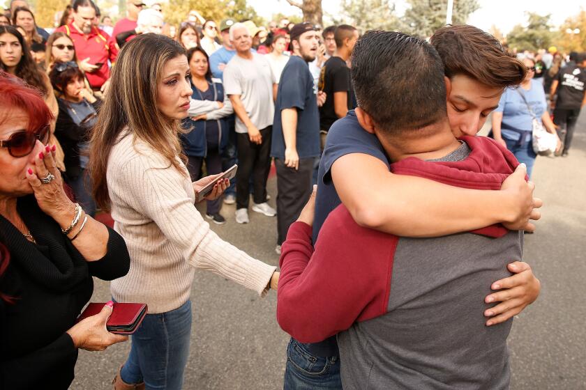 Photographs by Al Seib  Los Angeles Times SAUGUS HIGH SCHOOL student Dylan Reynoso, 16, hugs his father at the family reunification area after Thursday’s campus shooting.