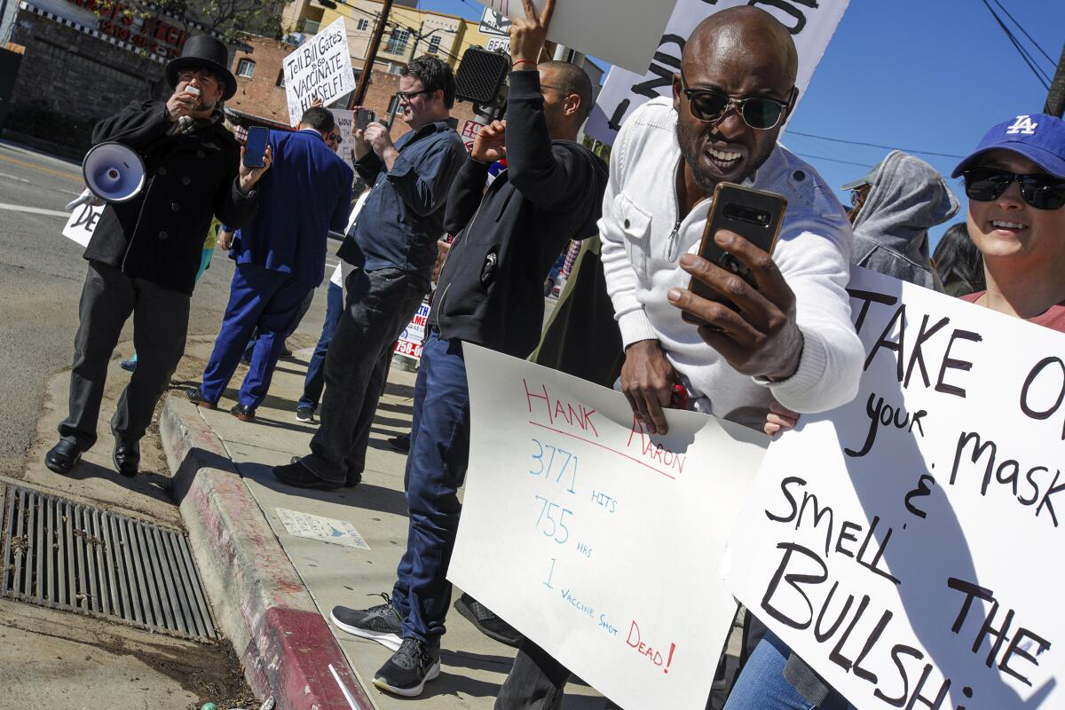 Siaka Massaquoi, right, listed on IMDb as an actor, protested the vaccine clinic at Dodger Stadium on Jan. 30.