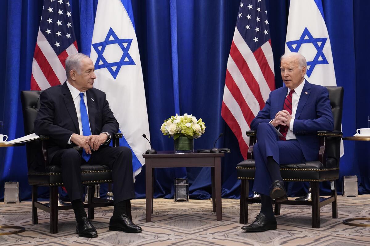 Benjamin Netanyahu and President Biden sit in front of U.S. and Israeli flags.