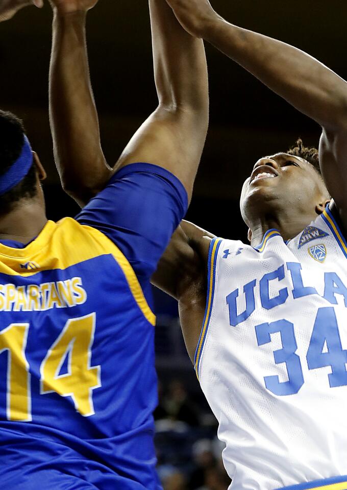 UCLA guard David Singleton battles San Jose State center Samuel Japhet-Mathias for a rebound.