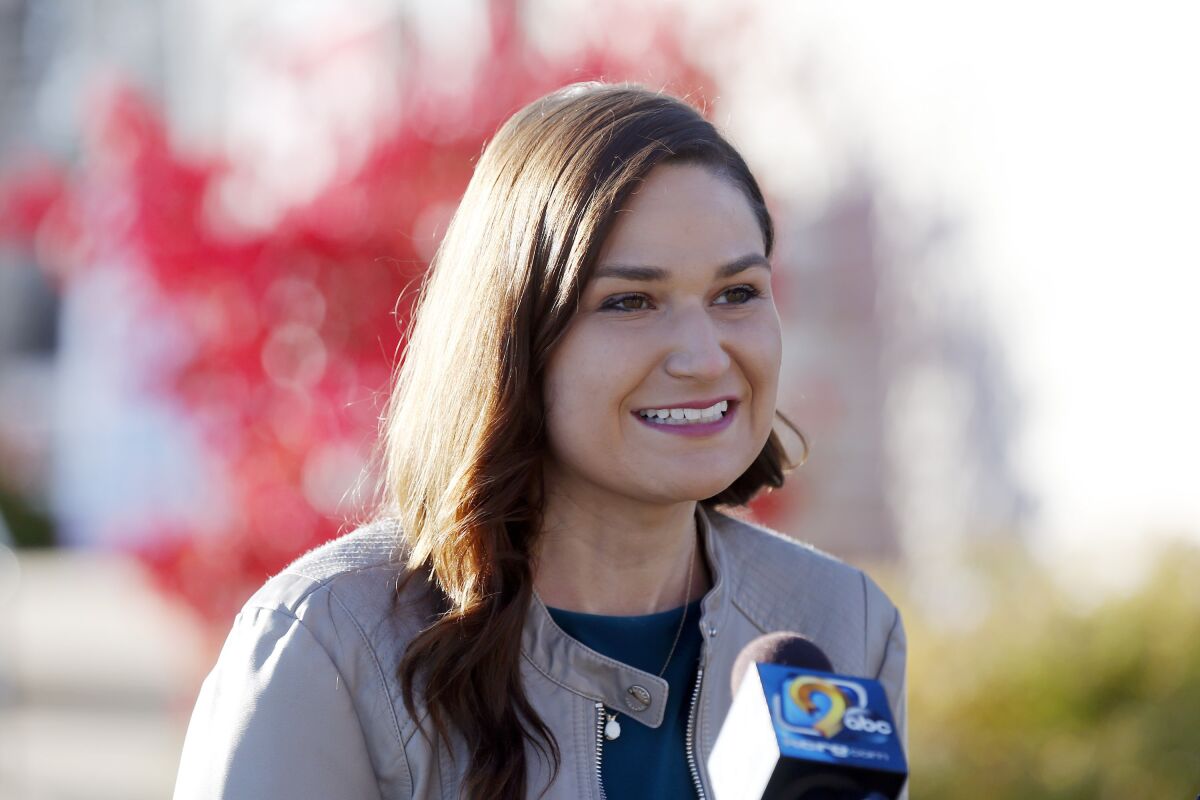 Abby Finkenauer smiles as a microphone is held near her. 