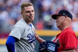 Los Angeles Dodgers first baseman Freddie Freeman receives his World Series championship ring from Atlanta Braves manager Brian Snitker (43) before a baseball game Friday, June 24, 2022 in Atlanta. (AP Photo/Butch Dill)