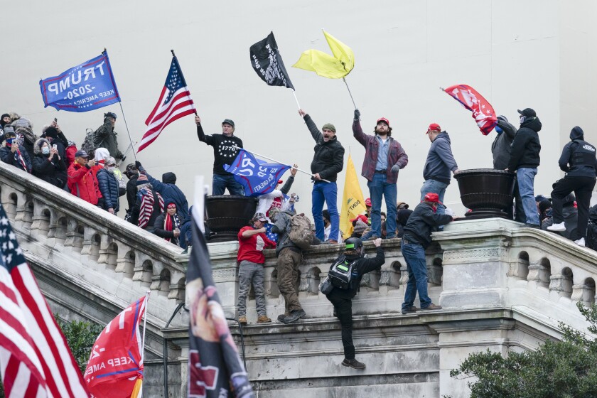 FILE - Rioters wave flags on the West Front of the U.S. Capitol in Washington on Jan. 6, 2021. As public trust in democratic institutions declines, conspiracy theories are filling the void. In some cases, that's leading believers to doubt even their own allies. (AP Photo/Jose Luis Magana, File)