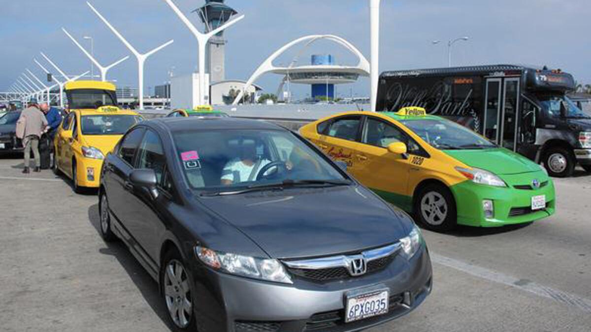 As part of the Uber settlement, the company is helping drivers form an association that will meet with Uber management to air grievances. Above, a driver with Uber and Lyft stickers at LAX.