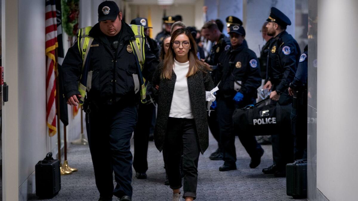 A woman is arrested after protesting in the Senate offices of Sen. Dianne Feinstein to demand that the Senate pass a bill that provides protections for people brought to the country illegally as children.