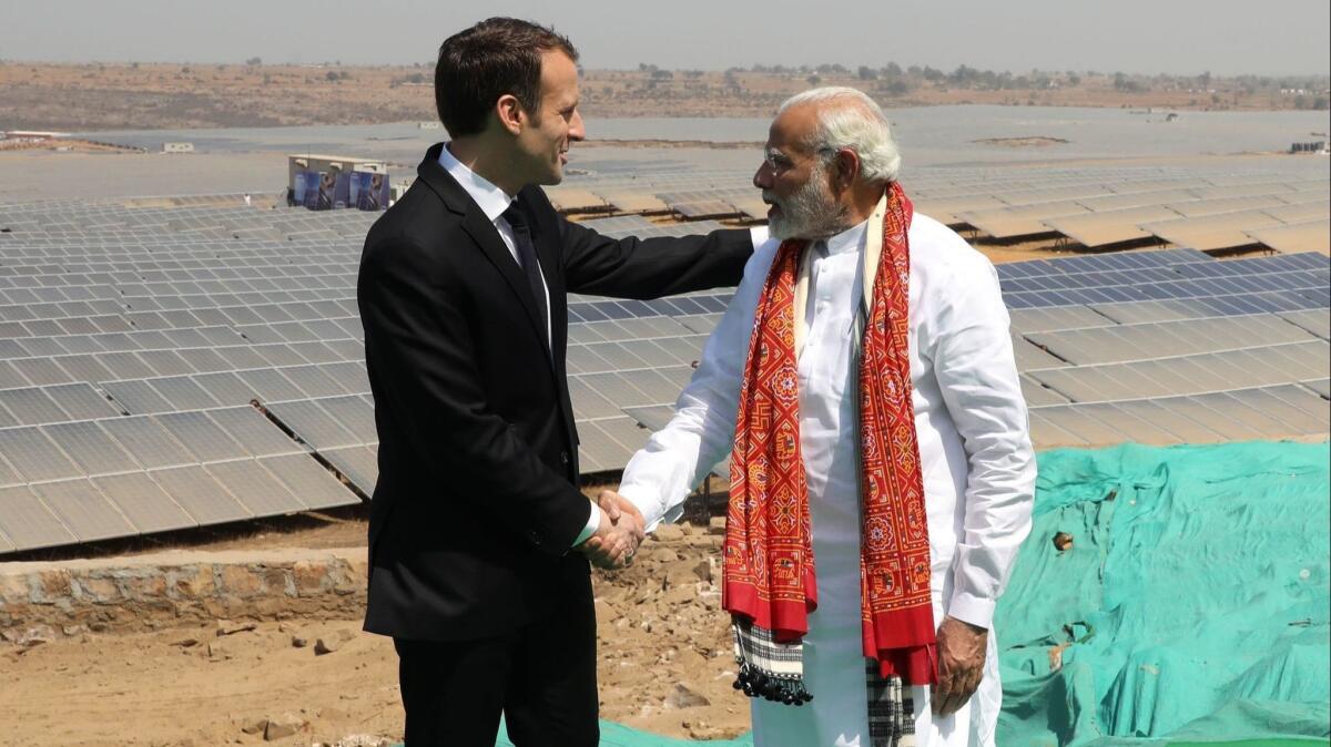 Indian Prime Minister Narendra Modi, right, and French President Emmanuel Macron visit a solar power plant in Mirzapur, India, on March 12.