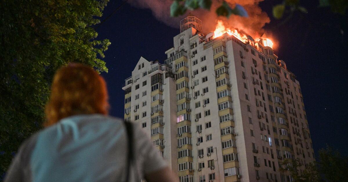 Photo: latimes.com A woman looks at an apartment building burning after a Russian missile attack in Kyiv, Ukraine, Thursday, July 2, 2026. (AP