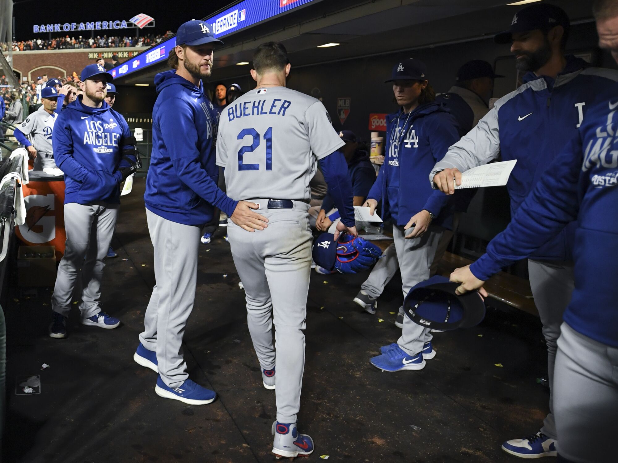 Los Angeles Dodgers' Clayton Kershaw meets with Walker Buehler in the dugout