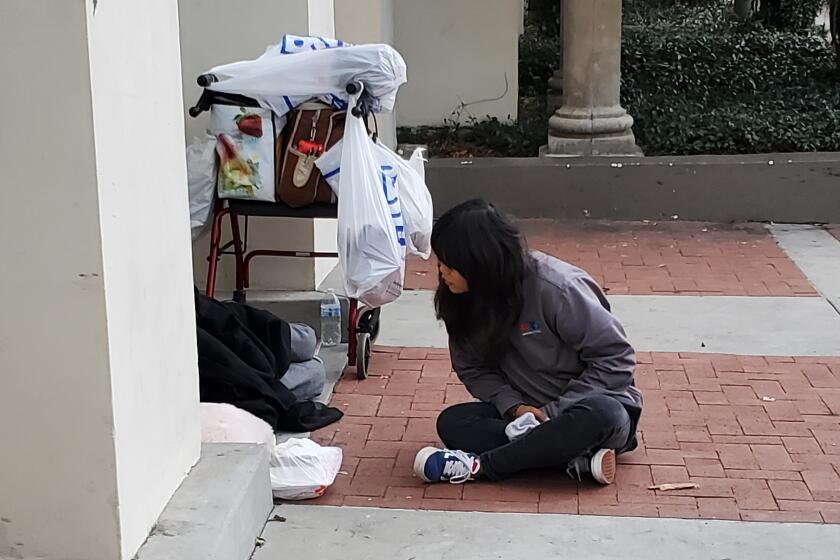 PATH lead outreach specialist Jayna Lee speaks to a man that was sleeping on the street.