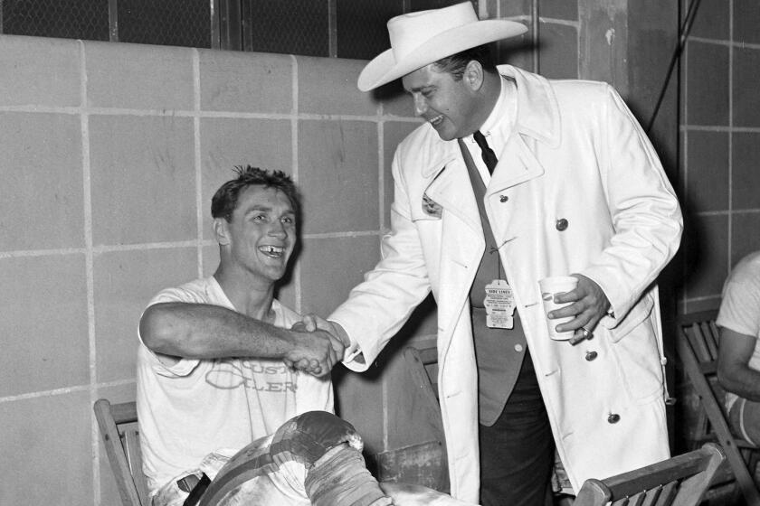 In this 1960 photo, Kenneth Stanley "Bud" Adams, right, shakes hands with the Houston Oilers' Billy Cannon in the dressing room in Houston. Adams died of natural causes in his Houston home, the Tennessee Titans announced Monday. He was 90.
