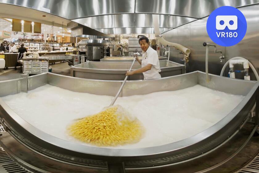 An employee at the La Habra Northgate market tortillaría stirs corn mixed with lime to ensure even nixtamilization.