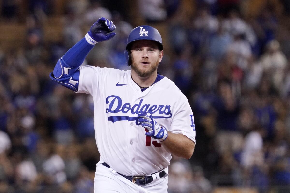 Dodgers' Max Muncy gestures as he heads to third after hitting a solo home run.