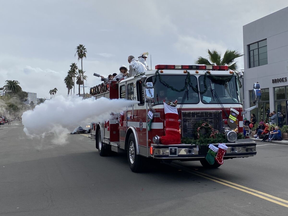 Parade-watcher Alex Minera, 7, of Encinitas said this firetruck was his favorite part ‘because it shoots snow.’