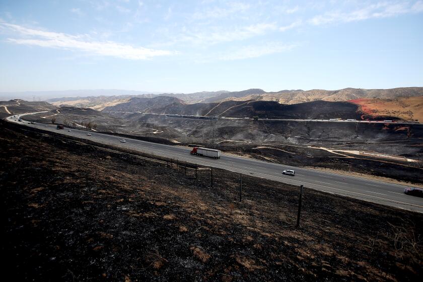 LAKE CASTAIC, CALIF. - SEP. 1, 2022. Motor traffic streams north and south on Interstate 5 through the burn zone of the Route fire near Lake Castaic on Thursday, Sept. 1, 2022. (Luis Sinco / Los Angeles Times)